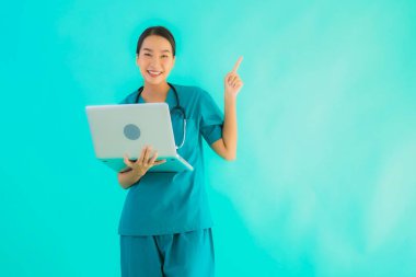 Mavi izole arka planda dizüstü bilgisayarı olan güzel Asyalı doktor kadın portresi.