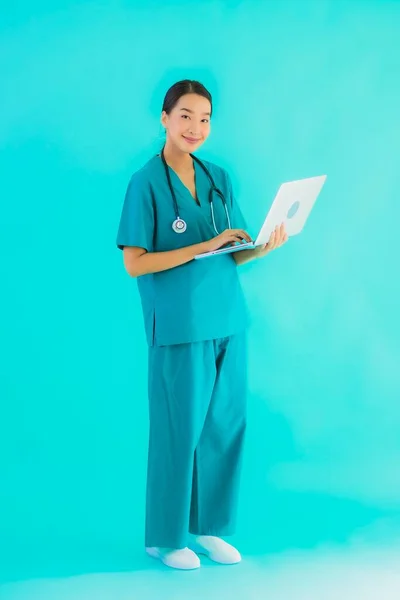 肖像画美しいです若いですアジアの医師女性とともにラップトップまたはコンピュータ上の青隔離された背景 — ストック写真