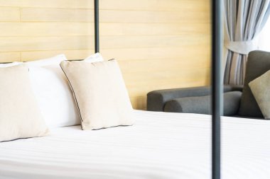 Otel odasındaki yatak odasının iç dekorasyonunda beyaz rahat yastık.