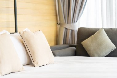 Otel odasındaki yatak odasının iç dekorasyonunda beyaz rahat yastık.