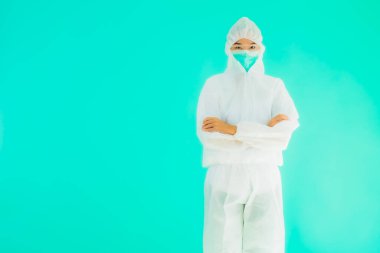 Güzel, genç Asyalı doktor kadın portre. Koronavirüsten ya da mavi arka planda kovid19 'dan korunmak için ppe ya da kişisel koruyucu ekipman takıyor.