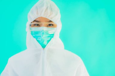 Güzel, genç Asyalı doktor kadın portre. Koronavirüsten ya da mavi arka planda kovid19 'dan korunmak için ppe ya da kişisel koruyucu ekipman takıyor.