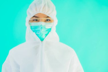 Güzel, genç Asyalı doktor kadın portre. Koronavirüsten ya da mavi arka planda kovid19 'dan korunmak için ppe ya da kişisel koruyucu ekipman takıyor.