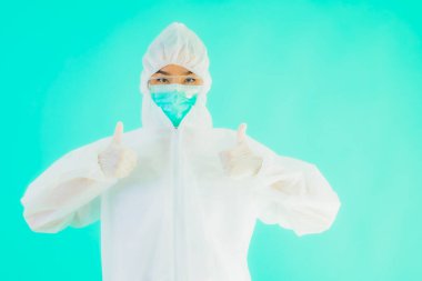 Güzel, genç Asyalı doktor kadın portre. Koronavirüsten ya da mavi arka planda kovid19 'dan korunmak için ppe ya da kişisel koruyucu ekipman takıyor.