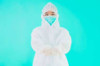 Güzel, genç Asyalı doktor kadın portre. Koronavirüsten ya da mavi arka planda kovid19 'dan korunmak için ppe ya da kişisel koruyucu ekipman takıyor.