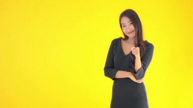 Sarıya izole edilmiş kameraya bakan güzel Asyalı kadın görüntüsü.