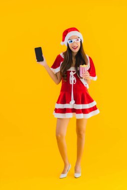 Güzel bir Asyalı kadın portresi patlamış mısır ve 3D gözlüklü noel şapkası takıyor sarı izole edilmiş arka planda film izlemeye hazır.