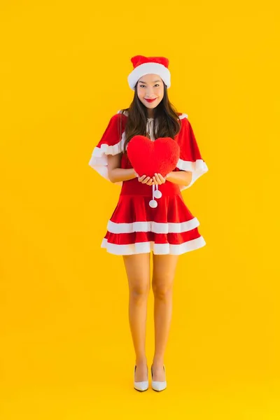 肖像画美しい若いアジアのクリスマスの服と帽子の笑顔幸せな心の形で黄色の孤立した背景 — ストック写真