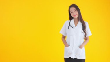 Sarıda izole edilmiş kameraya bakan güzel Asyalı doktor kadın görüntüleri.