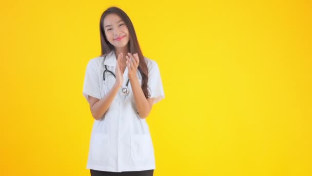 Imagens Bela Asiática Médico Mulher Batendo Palmas Isolado Amarelo — Vídeo de Stock