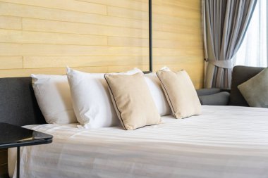 Otel odasındaki yatak odasının iç dekorasyonunda beyaz rahat yastık.