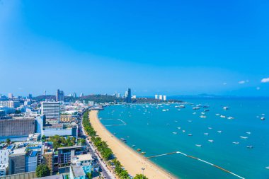 Beyaz bulut mavi gökyüzü ve Tayland 'ın Pattaya şehrindeki mimari yapı çevresindeki güzel tropikal sahil okyanus körfezi.