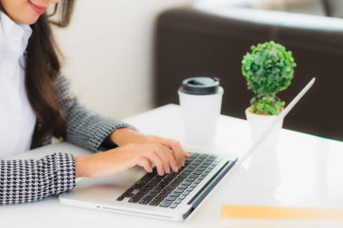 Güzel Asyalı iş kadını portresi evden bilgisayarlı cep telefonuyla karton kutuyla çevrimiçi alışveriş için hazır bekliyor.