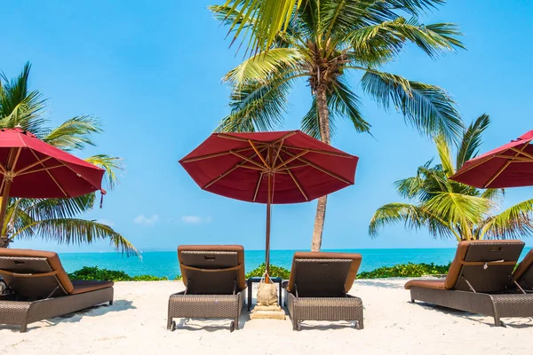 Güzel tropikal deniz okyanusu, şemsiyesi ve sandalyesi ile mavi gökyüzünde hindistan cevizi palmiyesinin etrafında tatil için