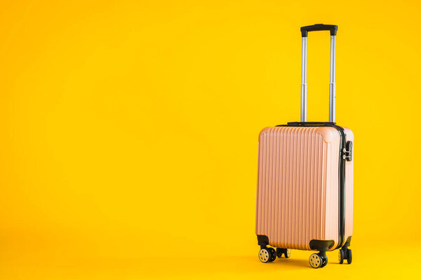 Pink color luggage or baggage bag use for transportation travel and leisure on yellow isolated background