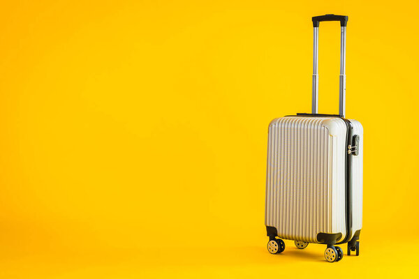 Gray color luggage or baggage bag use for transportation travel and leisure on yellow isolated background