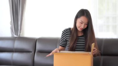 Evde çalışan güzel Asyalı kadının kasetlerinde paketler var.