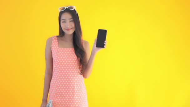 Кадри Красивої Азіатки Використанням Смартфона Ізольовані Жовтому — стокове відео