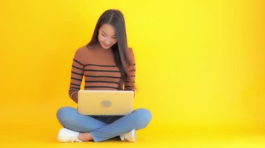 Güzel Asyalı bir kadının dizüstü bilgisayarla çalışırken çekilmiş görüntüleri.