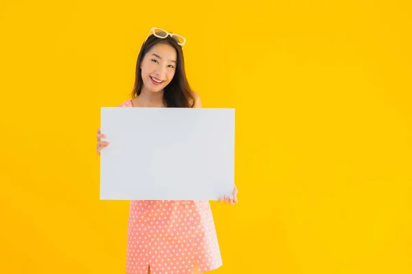 肖像美しい若いアジアの女性ショー空のホワイトBillboardのためにテキストとコピースペース上の黄色隔離された背景 — ストック写真