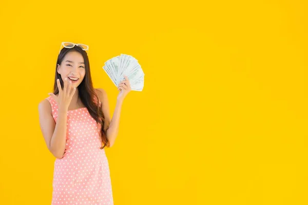 肖像美しい若いアジアの女性ショー多くの現金とお金上の黄色隔離された背景 — ストック写真