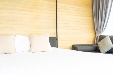 Otel odasındaki yatak odasının iç dekorasyonunda beyaz rahat yastık.