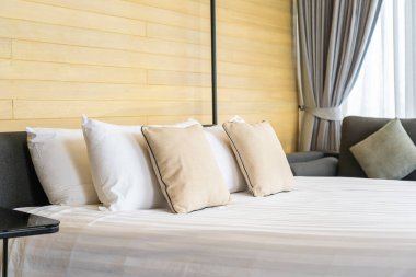 Otel odasındaki yatak odasının iç dekorasyonunda beyaz rahat yastık.