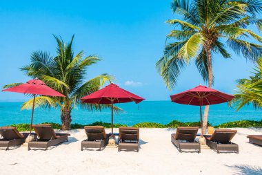 Güzel tropikal deniz okyanusu, şemsiyesi ve sandalyesi ile mavi gökyüzünde hindistan cevizi palmiyesinin etrafında tatil için