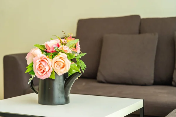客厅区域内用枕头和沙发装饰桌上的花朵 — 图库照片