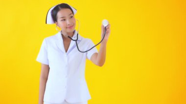 Sarıda steteskoplu güzel bir Asyalı hemşire görüntüsü.