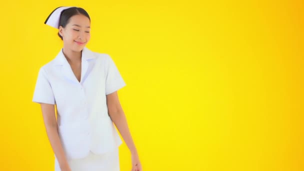 Кадры Красивой Азиатской Медсестры Изолированы Желтый — стоковое видео