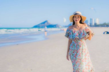 Güzel bir Asyalı kadın portresi. Mutlu bir gülümseme. Mavi gökyüzündeki tropikal deniz okyanusunda rahatla.