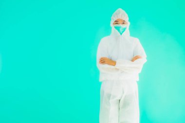 Güzel, genç Asyalı doktor kadın portre. Koronavirüsten ya da mavi arka planda kovid19 'dan korunmak için ppe ya da kişisel koruyucu ekipman takıyor.