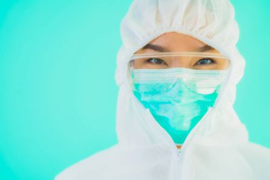 Güzel, genç Asyalı doktor kadın portre. Koronavirüsten ya da mavi arka planda kovid19 'dan korunmak için ppe ya da kişisel koruyucu ekipman takıyor.