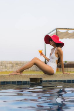 Asyalı genç bir kadının portresi mutlu bir gülümseme otel tatil beldesinde yüzme havuzunda rahatlamak