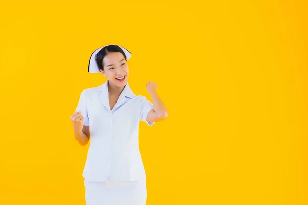 肖像画黄色の隔離された背景にクリニックや病院での患者のための多くのアクションの仕事で美しい若いアジアのタイの看護師 — ストック写真