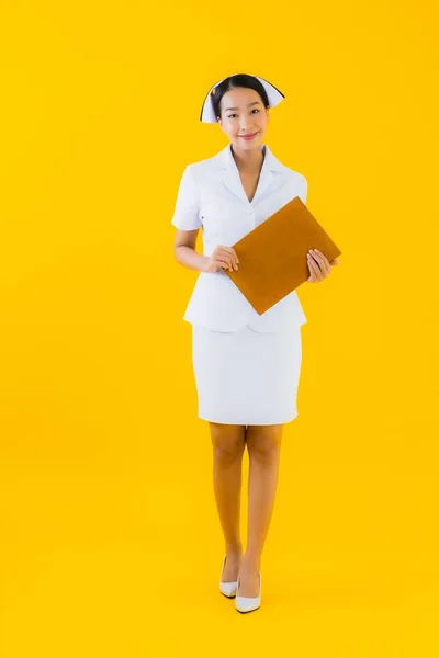 肖像美しい若いアジアの女性のタイの看護師は空のホワイトボードを表示し 黄色の隔離された背景にクリニックや病院で働く — ストック写真