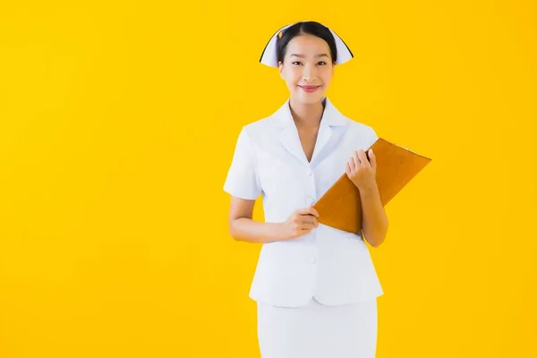 肖像美しい若いアジアの女性のタイの看護師は空のホワイトボードを表示し 黄色の隔離された背景にクリニックや病院で働く — ストック写真