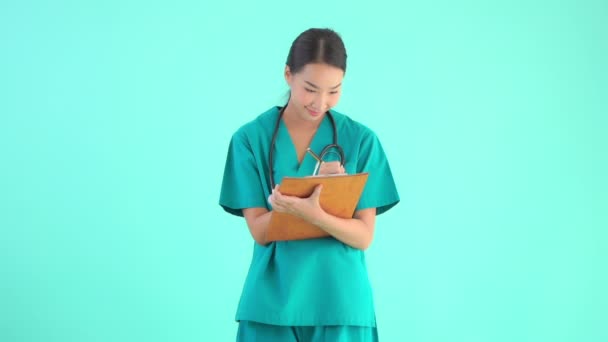 Záběry Krásné Asijské Ženy Lékař Psaní Schránce Izolované Modré — Stock video
