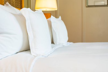 Yatak odasının iç tarafındaki yatak dekorasyonunda rahat beyaz yastık.