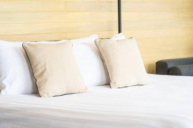 Otel odasındaki yatak odasının iç dekorasyonunda beyaz rahat yastık.