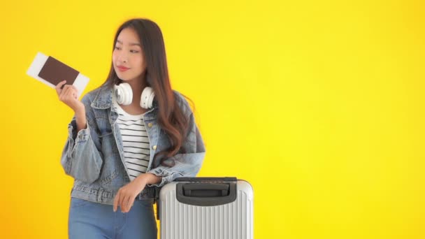 Beeldmateriaal Van Mooie Aziatische Vrouw Met Bagage Vliegticket Geïsoleerd Geel — Stockvideo