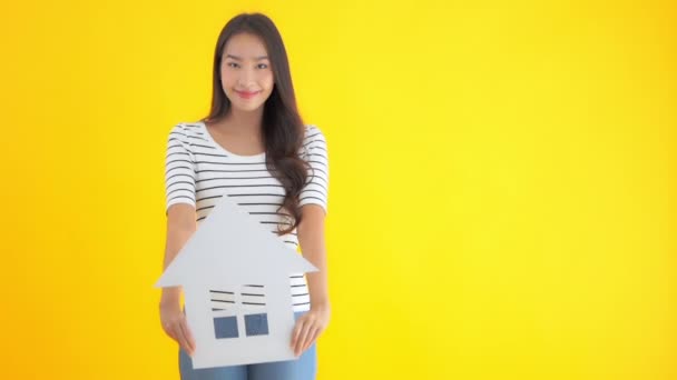 Footage Beautiful Asian Woman Cardboard House Sign Isolated Yellow — Stock Video