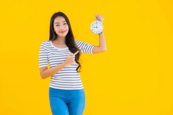 Портрет Красива Молода Азіатка Показує Годинник Або Будильник Жовтому Ізольованому — стокове фото