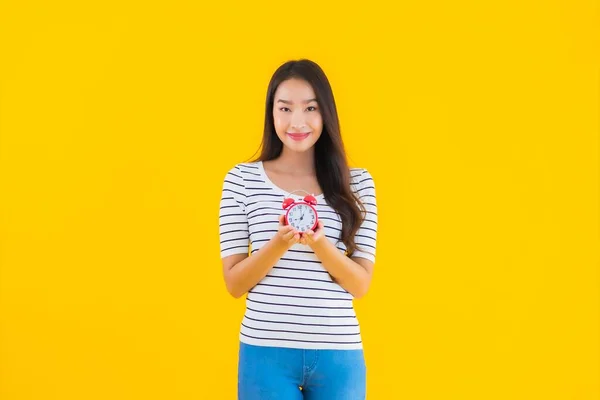 Портрет Красивая Молодая Азиатская Женщина Показывают Часы Будильник Желтом Изолированном — стоковое фото