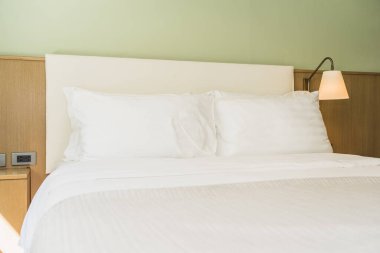 Yatak odasının iç dekorasyonunda beyaz rahat yastık.