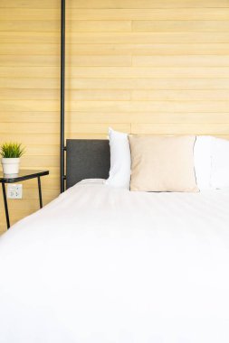 Otel odasındaki yatak odasının iç dekorasyonunda beyaz rahat yastık.