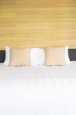 Otel odasındaki yatak odasının iç dekorasyonunda beyaz rahat yastık.