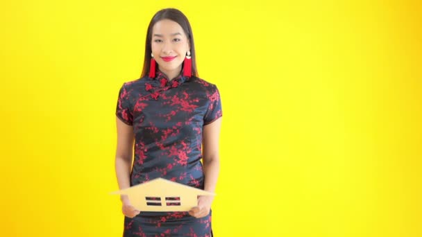 Materiał Piękną Azjatką Tradycyjnej Sukience Karton Dom Znak Izolowany Żółto — Wideo stockowe