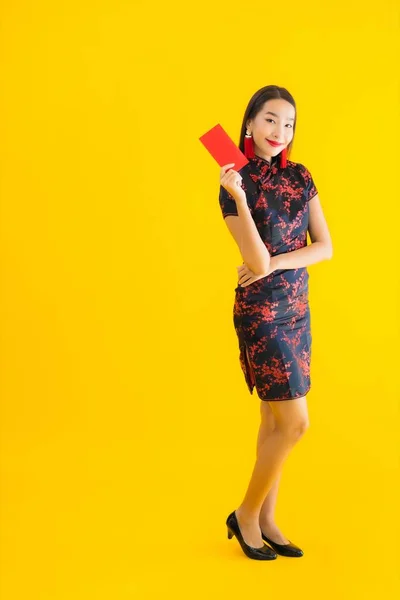 肖像美しい若いアジアの女性は 黄色の隔離された背景に中国の旧正月の概念のための現金と中国のドレスを着ている — ストック写真